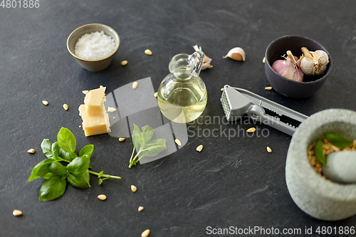 Image of ingredients for basil pesto sauce on stone table