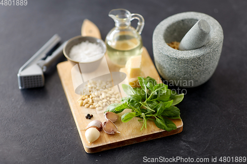 Image of ingredients for basil pesto sauce on wooden board