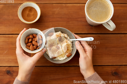 Image of hands with oatmeal breakfast and cup of coffee