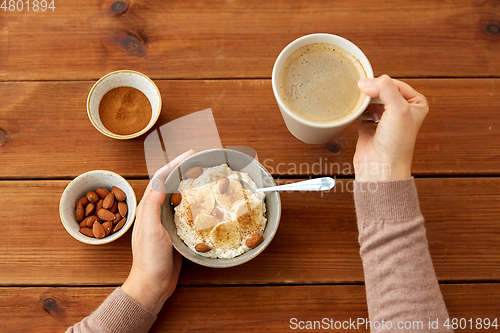 Image of hands with oatmeal breakfast and cup of coffee