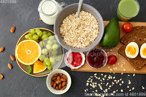 Image of oatmeal, fruits, toast bread, egg, jam and milk