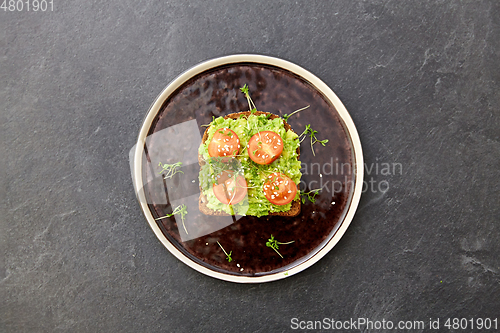 Image of toast bread with mashed avocado and cherry tomato