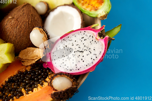 Image of plate of exotic fruits on blue background