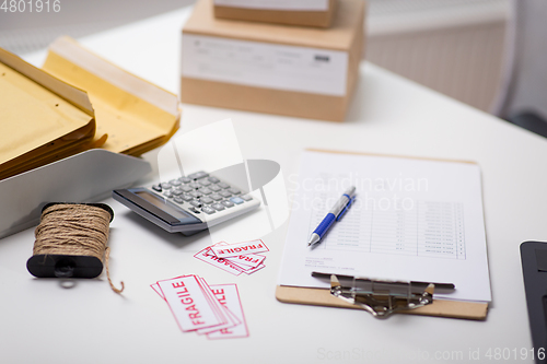 Image of calculator, clipboard and envelopes at post office