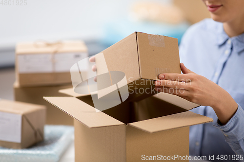 Image of woman packing parcel box at post office