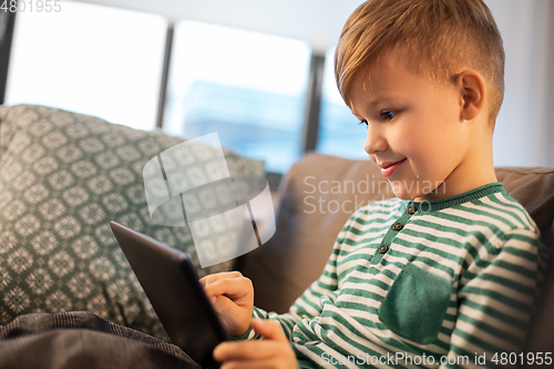 Image of happy little boy with tablet computer at home