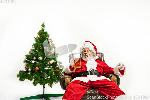 Image of Santa Claus drinking beer near Christmas tree, congratulating of New Year 2020