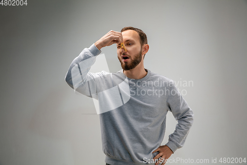 Image of Caucasian man wearing the respiratory protection pin clasp against air pollution and dusk on grey studio background