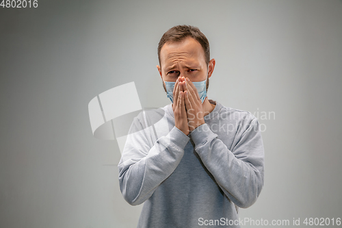 Image of Caucasian man wearing the respiratory protection mask against air pollution and dusk on grey studio background