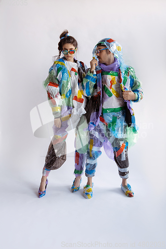 Image of Woman and man addicted of sales and clothes, wearing plastic, recycling concept