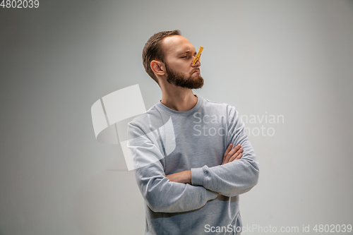 Image of Caucasian man wearing the respiratory protection pin clasp against air pollution and dusk on grey studio background