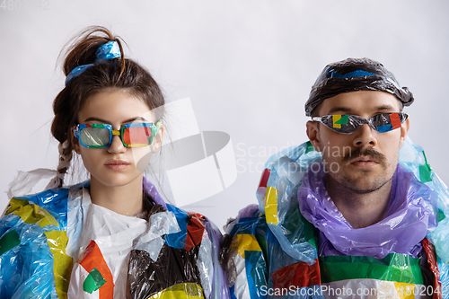 Image of Woman and man addicted of sales and clothes, wearing plastic, recycling concept