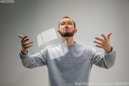 Image of Caucasian man wearing the respiratory protection pin clasp against air pollution and dusk on grey studio background