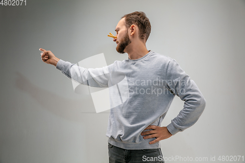 Image of Caucasian man wearing the respiratory protection pin clasp against air pollution and dusk on grey studio background