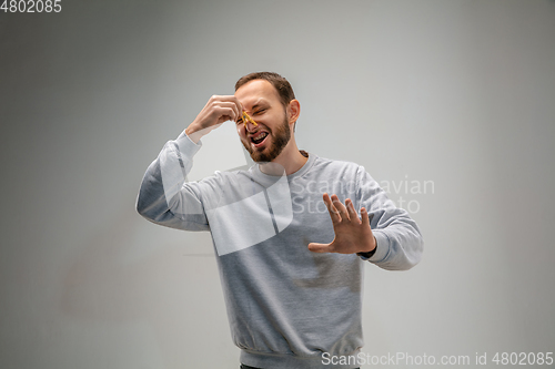 Image of Caucasian man wearing the respiratory protection pin clasp against air pollution and dusk on grey studio background