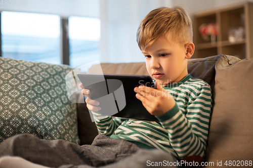 Image of happy little boy with tablet computer at home