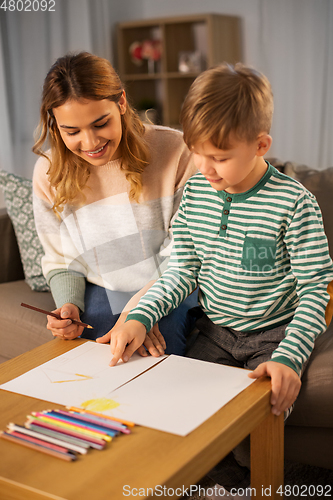 Image of mother and son with pencils drawing at home