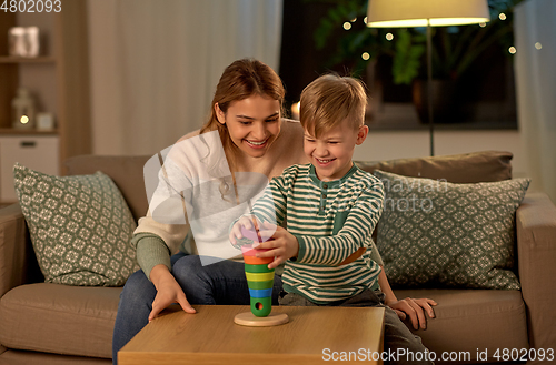 Image of mother and son playing with toy pyramid at home