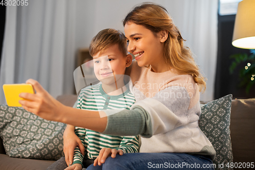 Image of mother and son taking selfie by smartphone at home