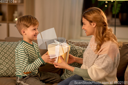 Image of little son giving present to mother at home