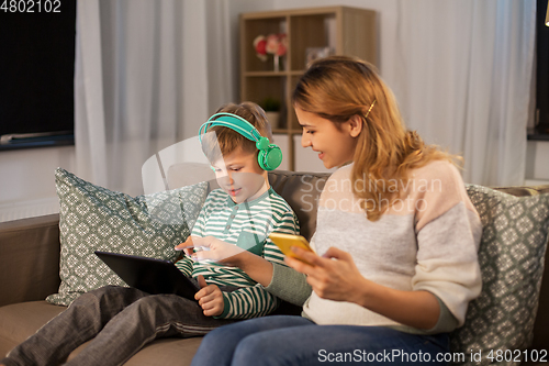 Image of mother and son using gadgets at home