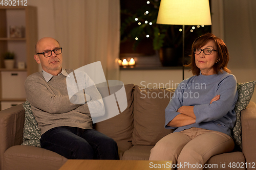 Image of unhappy senior couple sitting on sofa at home