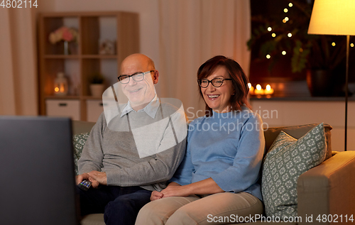 Image of happy senior couple watching tv at home