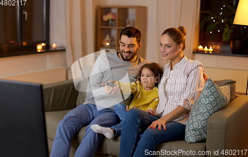 Image of happy family watching tv at home at night