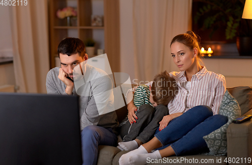 Image of family watching something boring on tv at night
