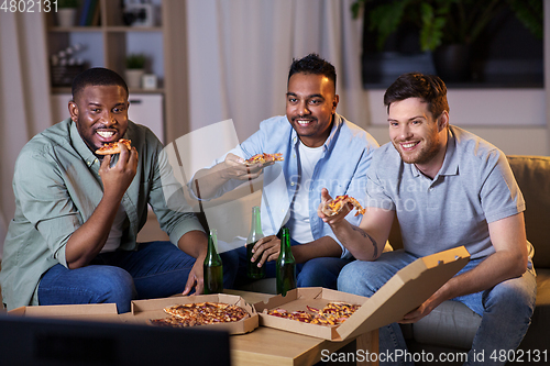 Image of happy male friends with beer eating pizza at home