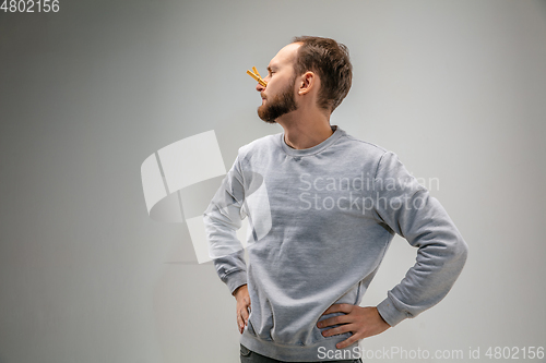 Image of Caucasian man wearing the respiratory protection pin clasp against air pollution and dusk on grey studio background
