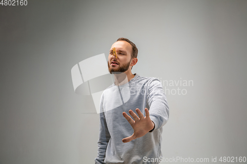 Image of Caucasian man wearing the respiratory protection pin clasp against air pollution and dusk on grey studio background