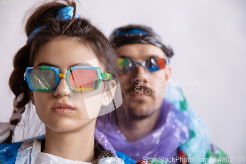 Image of Woman and man addicted of sales and clothes, wearing plastic, recycling concept