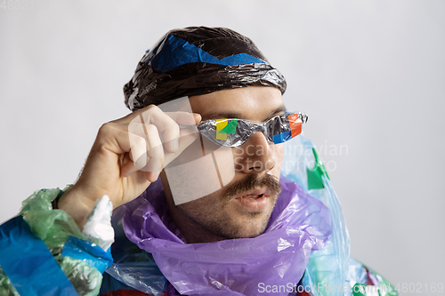 Image of Man addicted of sales and clothes, wearing plastic, recycling concept