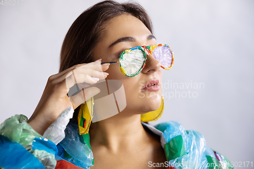 Image of Woman addicted of sales and clothes, wearing plastic, recycling concept