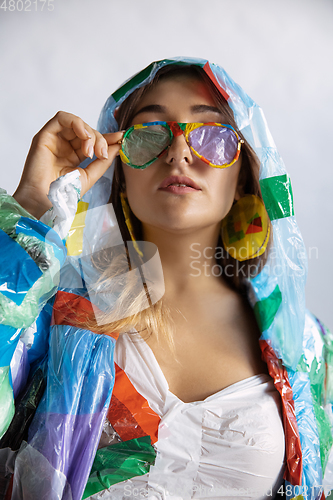 Image of Woman addicted of sales and clothes, wearing plastic, recycling concept