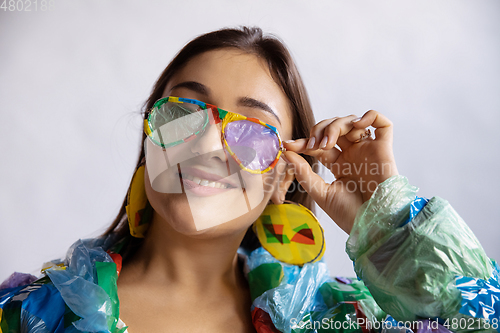 Image of Woman addicted of sales and clothes, wearing plastic, recycling concept