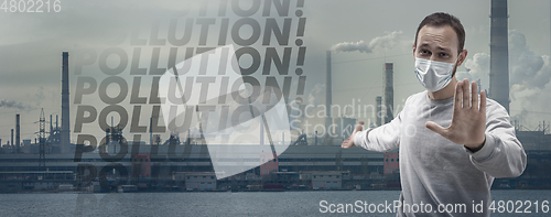 Image of Caucasian man wearing the respiratory protection mask against air pollution and dusk with factories on background