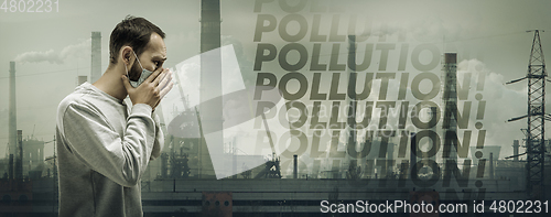 Image of Caucasian man wearing the respiratory protection mask against air pollution and dusk with factories on background