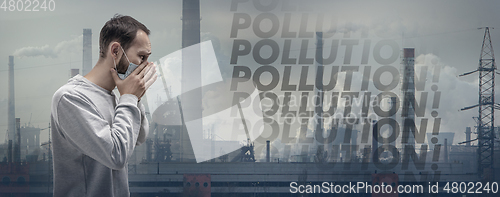 Image of Caucasian man wearing the respiratory protection mask against air pollution and dusk with factories on background