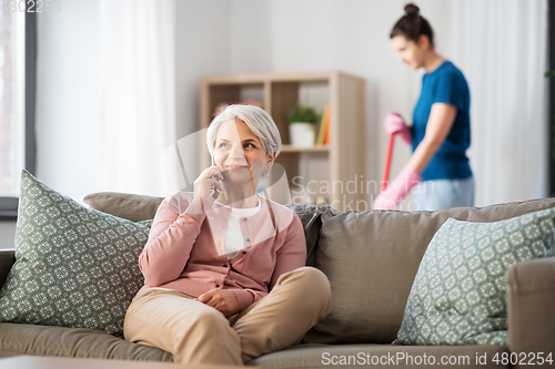 Image of happy senior woman calling on smartphone at home