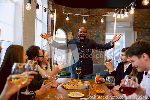 Image of Happy co-workers celebrating while company party and corporate event