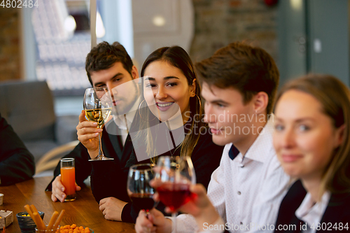 Image of Happy co-workers celebrating while company party and corporate event