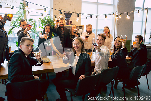 Image of Happy co-workers celebrating while company party and corporate event