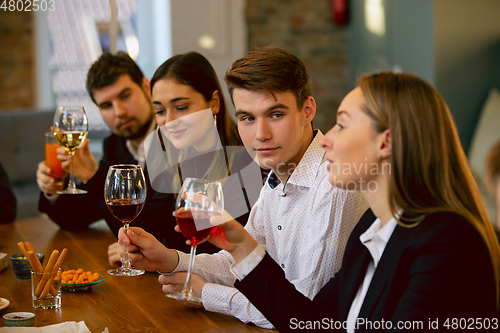 Image of Happy co-workers celebrating while company party and corporate event