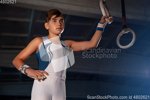 Image of Little male gymnast training in gym, flexible and active