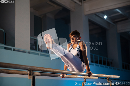 Image of Little male gymnast training in gym, flexible and active