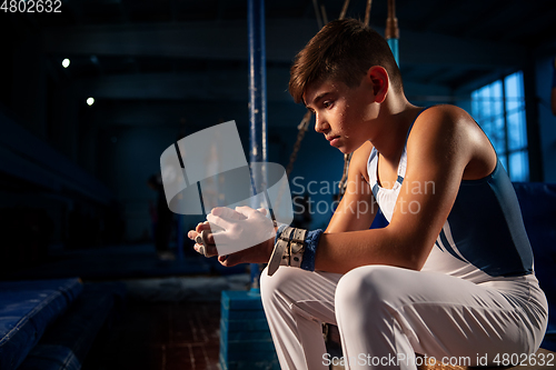 Image of Little male gymnast training in gym, flexible and active