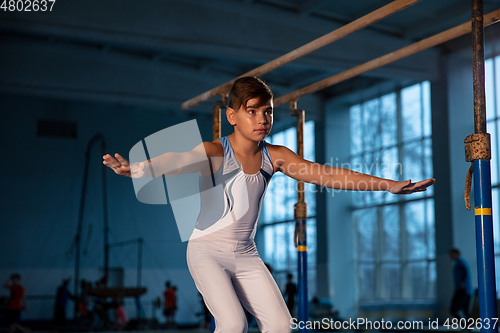 Image of Little male gymnast training in gym, flexible and active