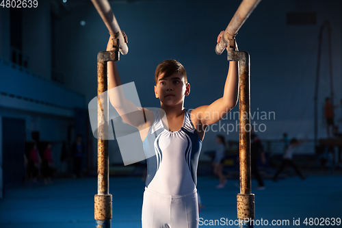 Image of Little male gymnast training in gym, flexible and active